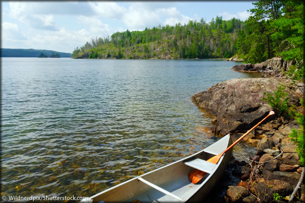 A lake with canoe on the shore